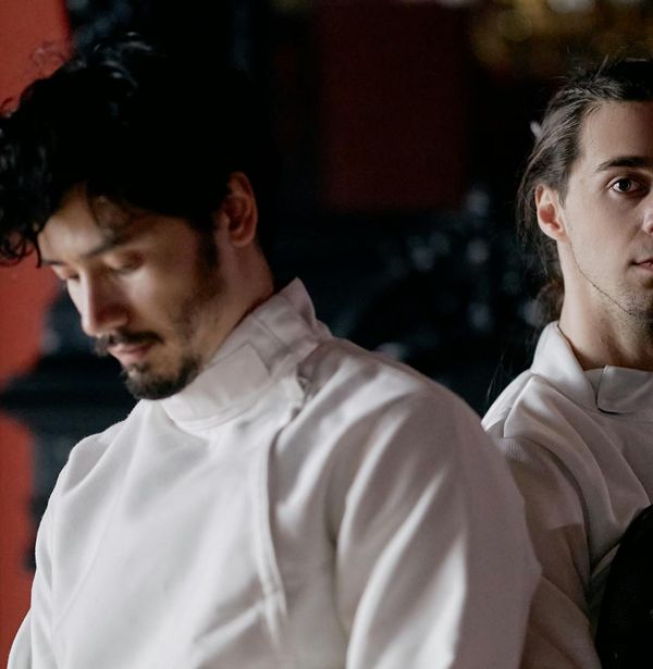 A man doing a dynamic warm-up exercise with focused expression.