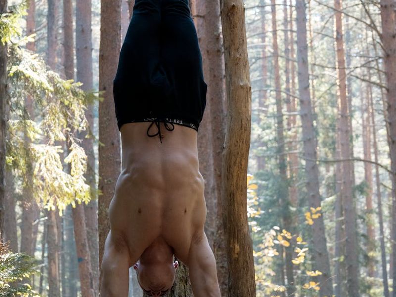 Man performing a controlled bodyweight exercise in a minimalist gym setting.